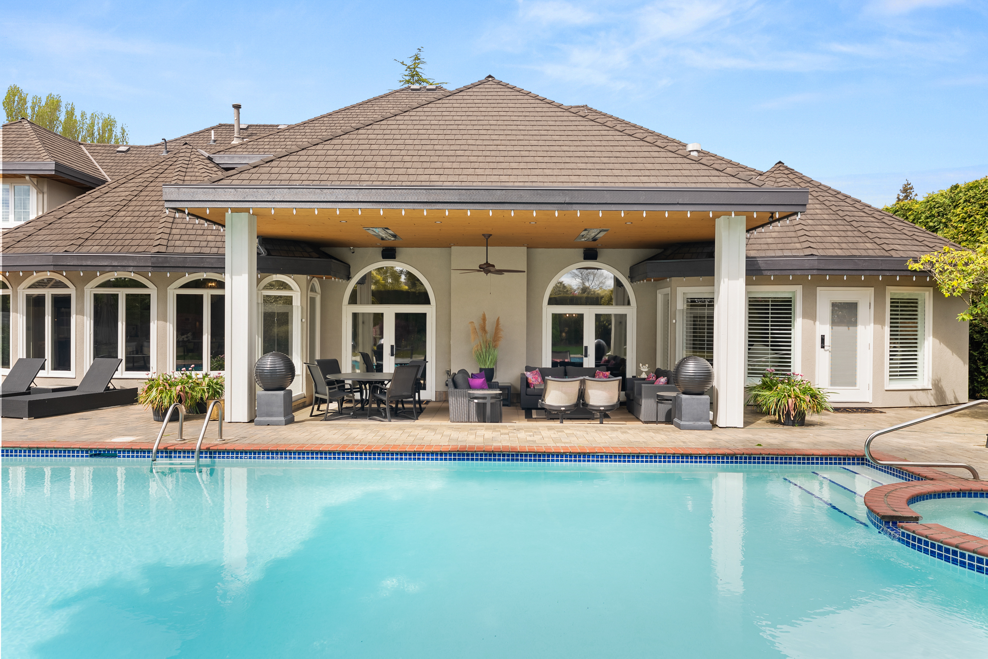 Poolside covered patio with lounge and dining areas